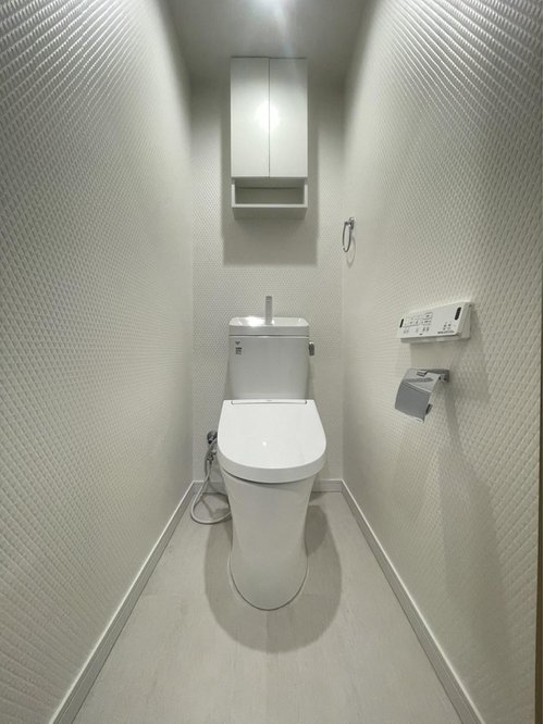 清掃用品やトイレットペーパーを収納できる吊戸棚を新規設置