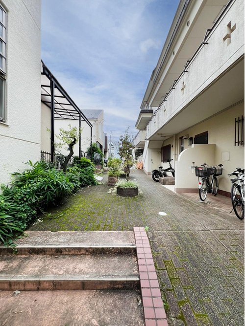 帰宅が楽しみになるお洒落なアプローチです。
レンガ調の階段とタイル張りの通路、緑の植栽が迎えてくれる、素敵なエントランス空間。毎日の出入りが心地よくなります。